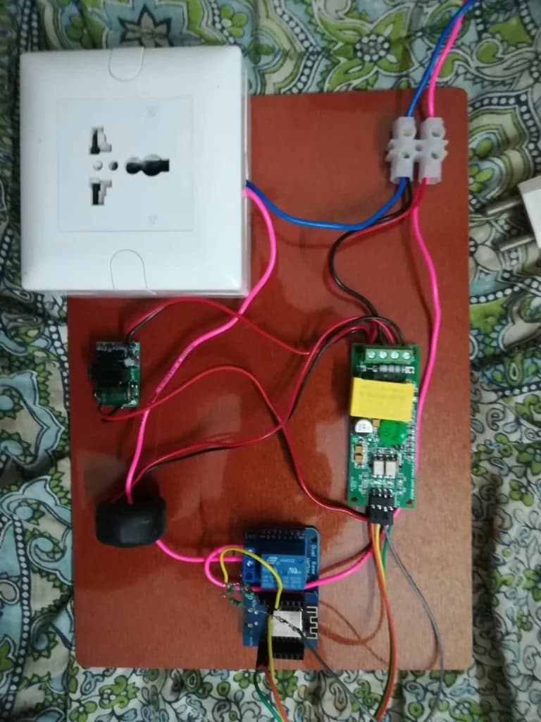 Early co-working energy monitor prototype with PZEM-004T, ESP8266, and relay on a wooden mounting board